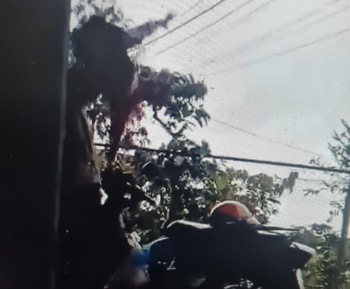 Người cha cầm áo nhấc bổng đứa bé lên cao dọa ném xuống đất. (Ảnh: Chụp màn hình)