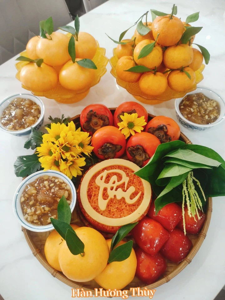 Mâm lễ mùng 1 tháng 10 có bánh bao và bánh xu xê tạo màu từ gấc tươi. Đĩa bên trái là bánh bao, đĩa bên phải mới là cam thật.