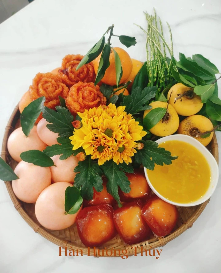 Mâm lễ rằm tháng 6 nhuận với bánh và xôi tạo màu từ gấc tươi.