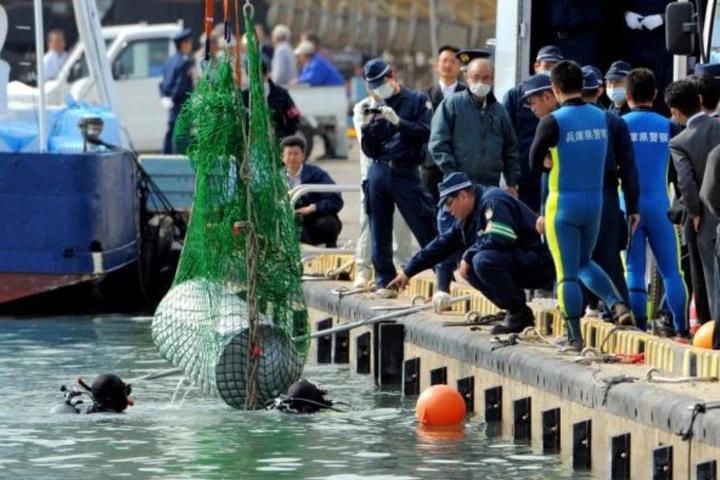 Cảnh sát trục vớt chiếc thùng phuy chứa thi thể của ông Hashimoto. (Nguồn: Asahi Shimbun)