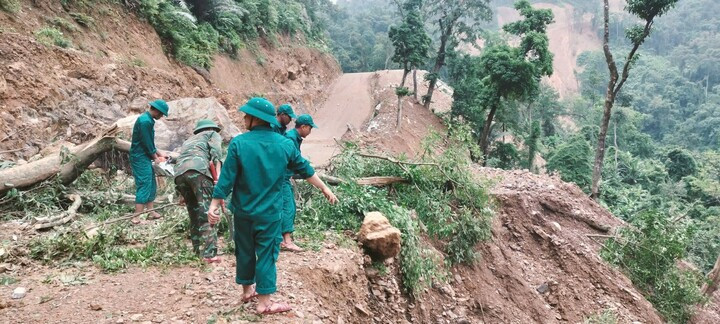 Ban Chỉ huy Quân sự xã Trường Sơn khắc phục sự cố sạt lở đất, cây đổ chắn ngang đường. (Ảnh: Hoàng Cuối)
