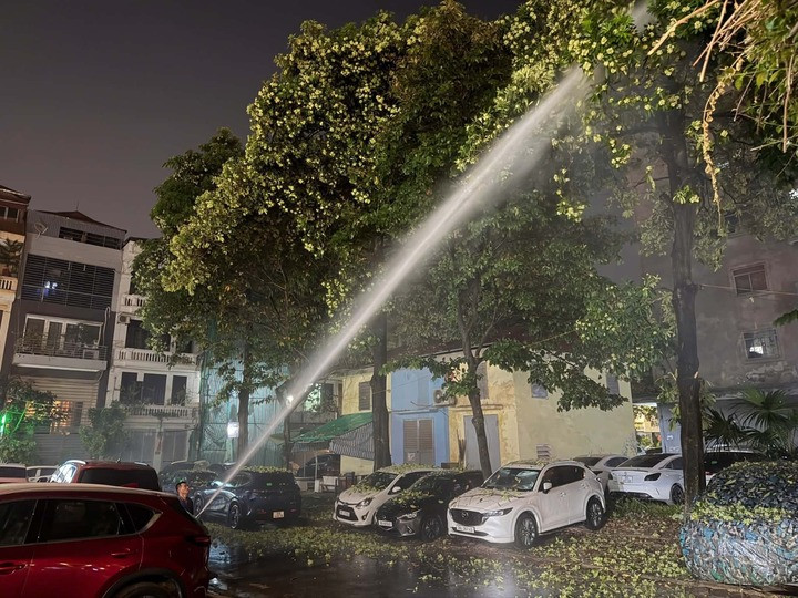 Người dân dùng vòi nước xịt rụng hoa sữa nhằm giảm mùi nồng nặc.