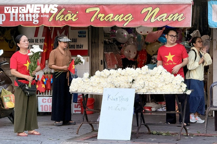 Một cửa hàng trên đường Trường Sơn chuẩn bị hàng trăm bông cúc trắng, đặt biển “Kính tặng miễn phí” để người dân mang theo tiễn biệt các liệt sĩ.