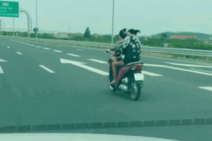 Hai phụ nữ 'đầu trần' lạng lách xe máy trên cao tốc, người ngồi sau ôm búp bê