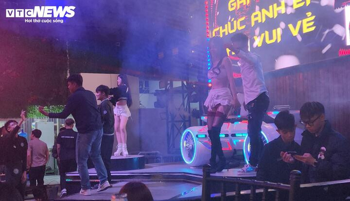 Nhiều thực khách lên sân khấu lắc lư cùng 2 nữ nhân viên như khung cảnh trong một quán bar.