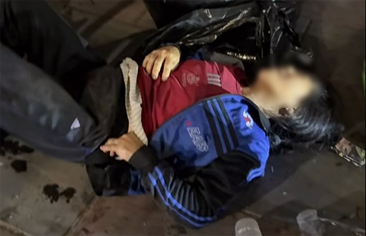 Nạn nhân đau đớn nằm kêu cứu trên vỉa hè sau khi bị ô tô tông trúng. (Ảnh cắt từ clip)