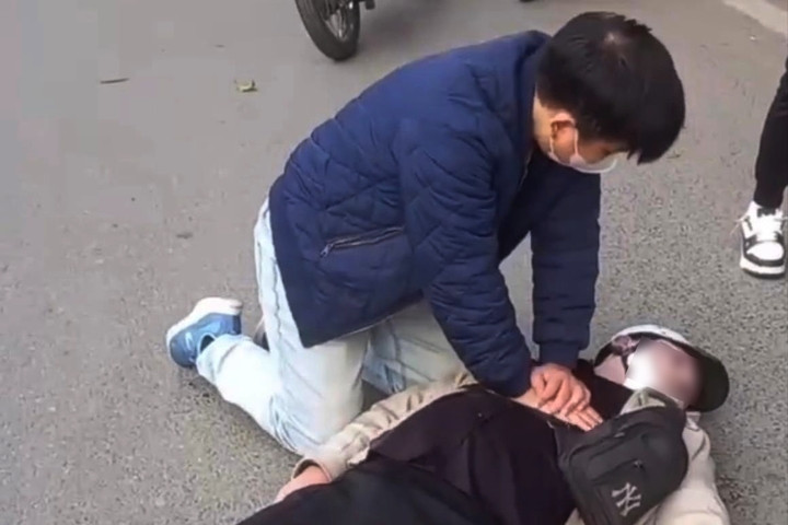 Bác sĩ Tiến ép tim cứu người đi đường ngừng tuần hoàn. (Ảnh cắt từ clip)