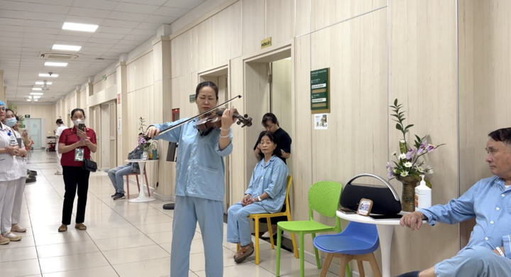 Trong bộ quần áo bệnh nhân giản dị, chị Nguyệt Thu say sưa chơi nhạc tri ân y bác sỹ.