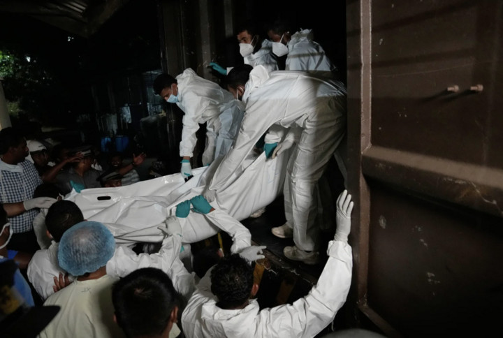 Các nhân viên y tế đang đưa thi thể các thuỷ thủ Iran thiệt mạng khỏi tàu khu trục IRIS Dena bị chìm. (Nguồn: AP)