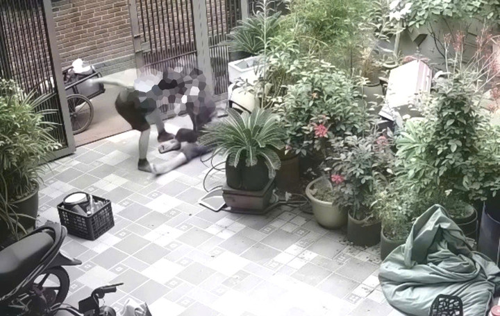 Hình ảnh người chồng bạo hành vợ dã man ngay ngoài cổng nhà. (Ảnh cắt từ clip).