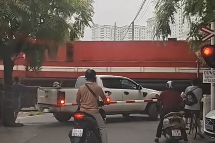 Tài xế bán tải cố tình điều khiển xe vượt qua dù rào chắn đang hạ xuống.