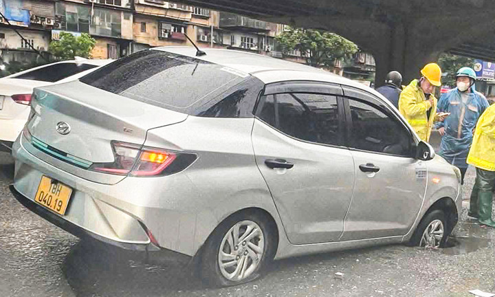 Xe taxi sụt hố trên đường Khuất Duy Tiến. (Ảnh: Đ.A.)