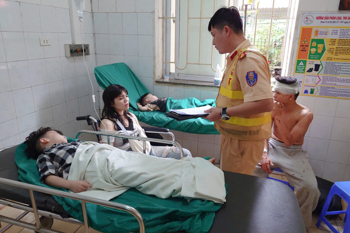 Cán bộ Phòng CSGT Công an tỉnh Sơn La hỏi thăm tình hình sức khỏe của những người bị thương. (Ảnh: C.T.)