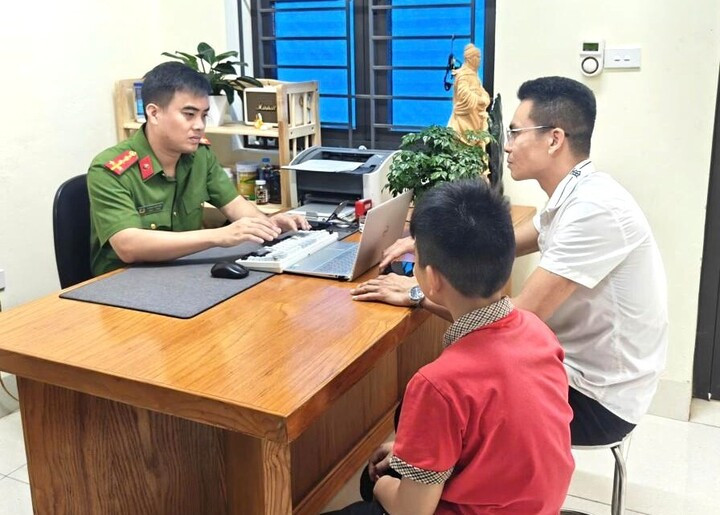 Cháu Dương Minh Hiếu cùng người bác ruột làm việc tại cơ quan công an. (Ảnh: Công an xã Kép)