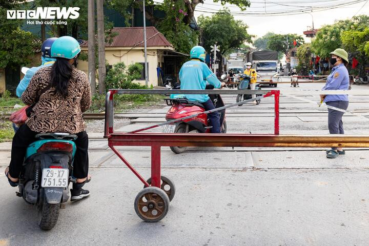 Tại ngã ba Ngọc Hồi - thị trấn Văn Điển, dù barie gần như khép kín và chuông cảnh báo liên tục vang lên, nhiều người vẫn cố len qua khoảng hở nhỏ.