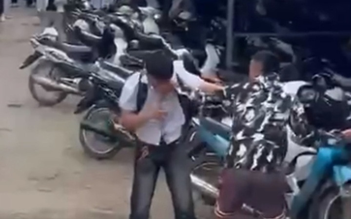 Hình ảnh nam sinh lớp 12 bị những thanh niên lạ mặt xông vào trường hành hung. (Ảnh cắt từ clip)