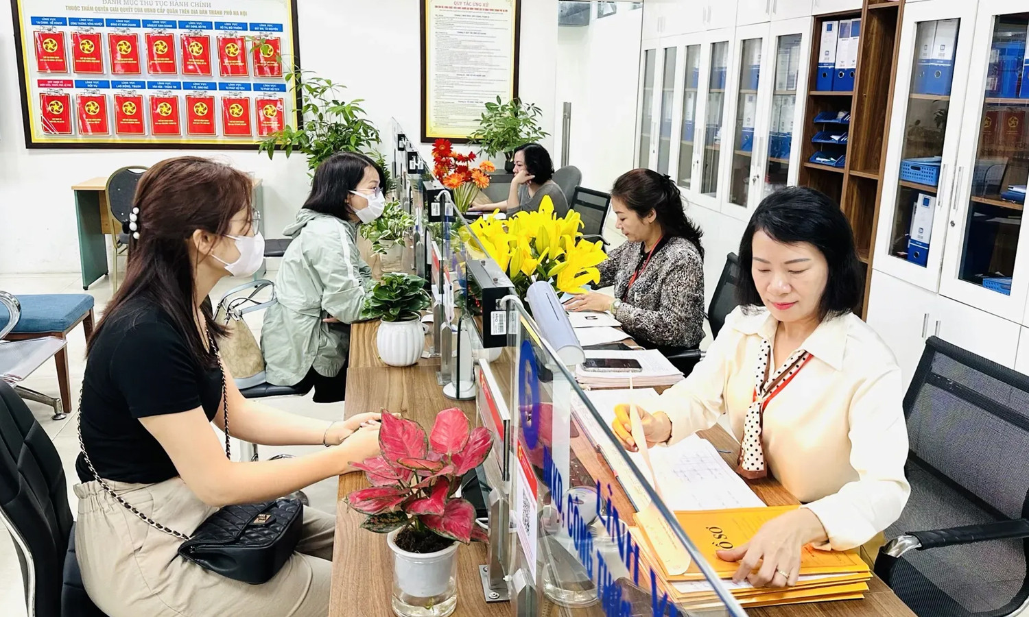 Công chức phường tại TP Hà Nội hỗ trợ người dân giải quyết thủ tục hành chính.