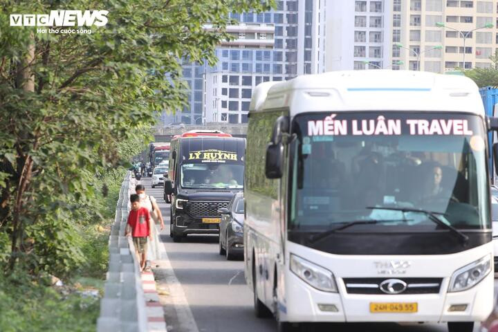 Tại nút giao cao tốc Pháp Vân - Cầu Giẽ và đường Đỗ Mười (phường Yên Sở, Hà Nội), ô tô di chuyển chậm chạp, nhiều người xuống xe khách đi bộ để nhanh chóng thoát khỏi cung đường ùn tắc.