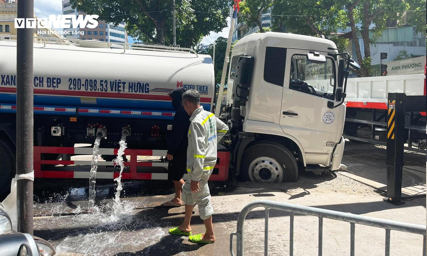 Bánh trước của xe phun nước rửa đường bị sụt hố.
