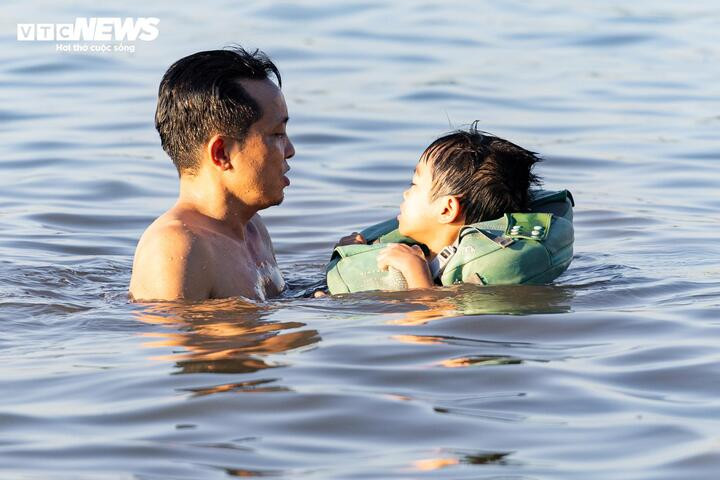 “Những ngày nắng nóng, tôi thường đưa các con ra bãi sông Hồng gần nhà để bơi, tắm mát thay vì ở nhà chơi điện thoại hay máy tính trong kỳ nghỉ hè”, anh Hoàng chia sẻ.