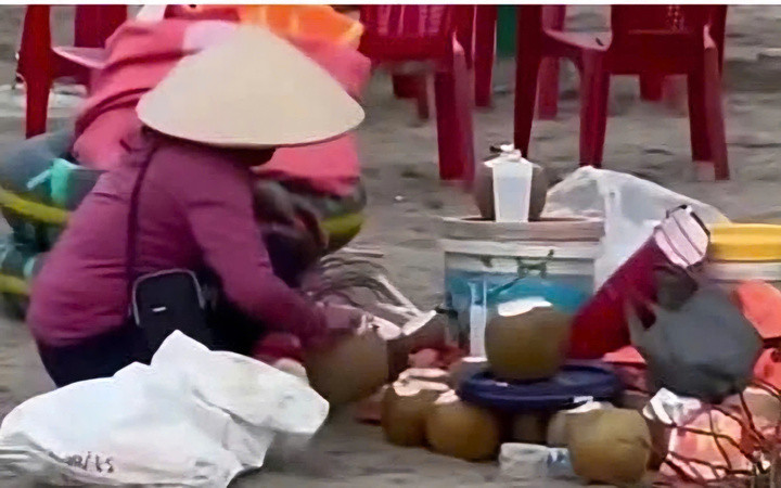 Hình ảnh bà X. gom nước dừa thừa để tái sử dụng được du khách ghi lại.