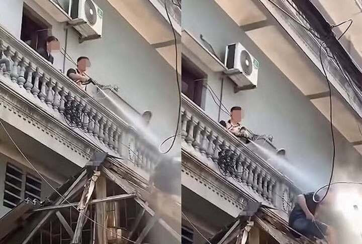 Hình ảnh người đàn ông xịt nước vào thợ đang thi công. (Ảnh cắt từ clip)