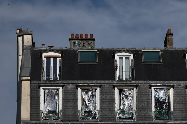 Người dân ở Paris phủ chăn giữ nhiệt lên cửa sổ để giảm sức nóng từ ánh nắng. (Ảnh: Reuters)