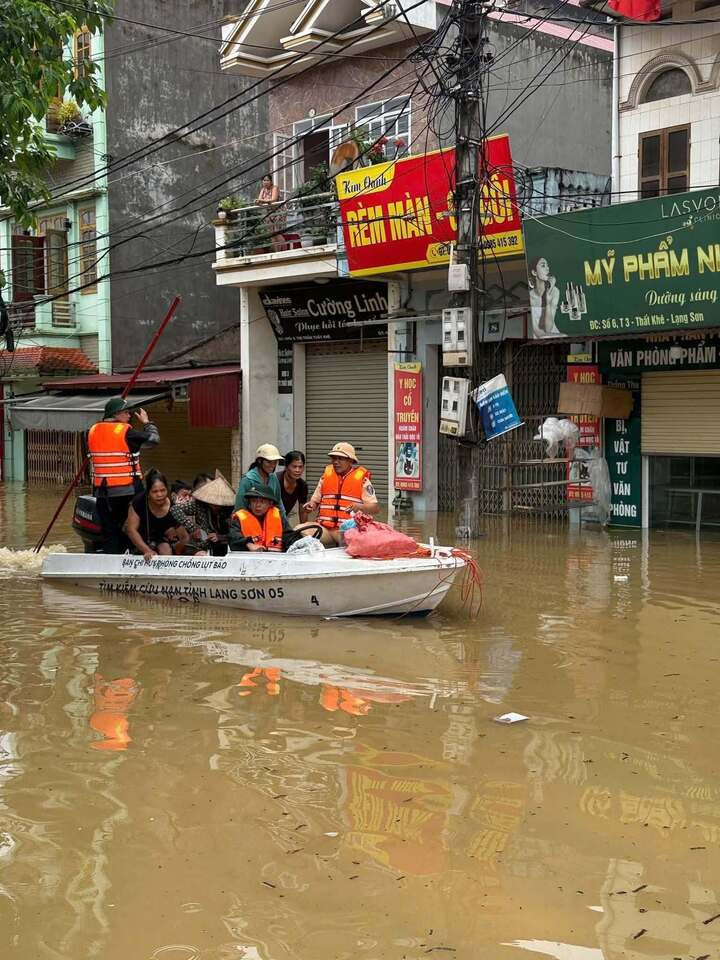 Lực Lượng chức năng đi cano ứng cứu người dân khỏi khu vực ngập sâu.