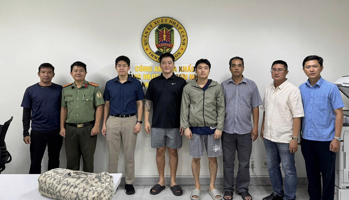 Lực lượng công an bàn giao 2 đối tượng Bang Giseong và Han Joohee cho phía Hàn Quốc (quần cộc, đứng giữa). (Ảnh: CACC)
