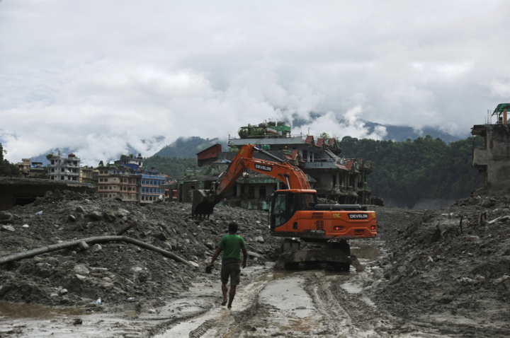 Máy xúc dọn sạch con đường lầy lội sau trận lũ quét và sạt lở đất ở Nepal. (Ảnh: Reuters)