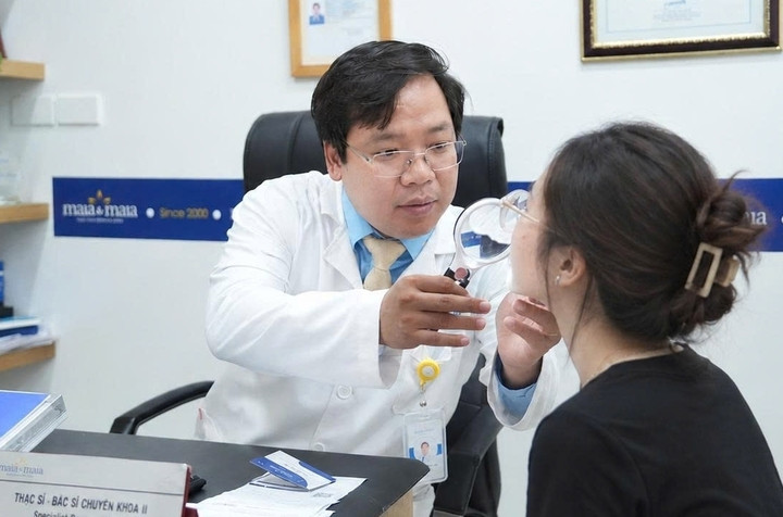 Bác sĩ Thành kiểm tra tình trạng tổn thương trên da mặt bệnh nhân. (Ảnh: BSCC)